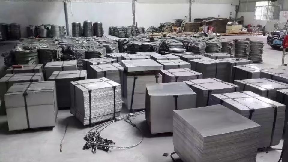 Stainless steel sheet materials bundled and stored in a warehouse, prepared for industrial fabrication and custom processing.