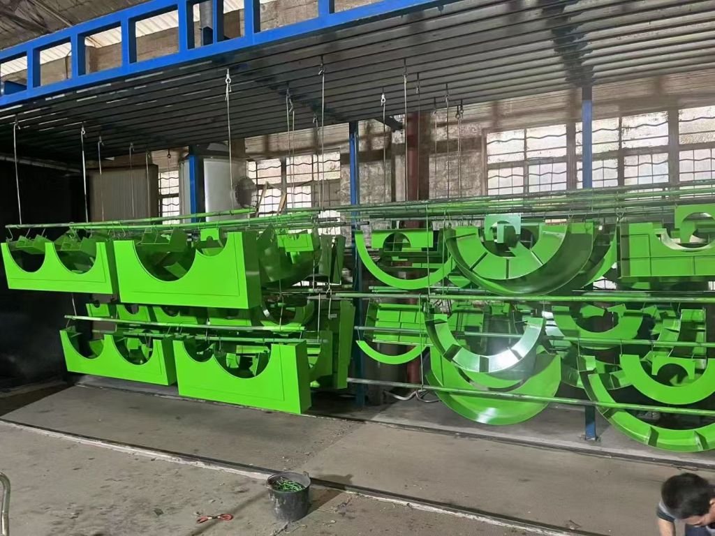 Bright green powder-coated custom metal components in coating workshop