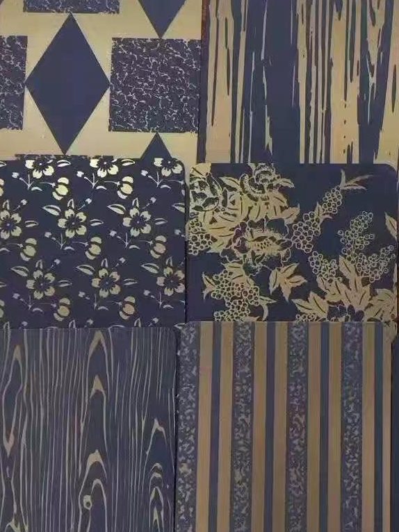 Stainless steel surface finish samples showing brushed and decorative textures in multiple metallic tones. Decorative stainless steel surface finish samples featuring gold, black and bronze tones with geometric, linear, etched and patterned textures for custom stainless steel surface finishing projects.