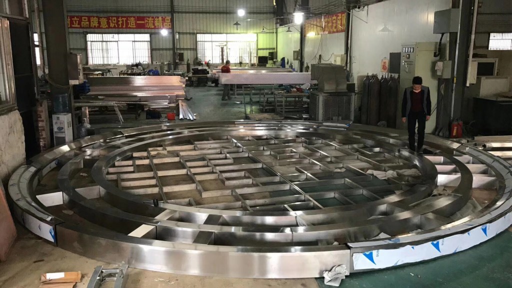 Custom fabricated stainless steel curved components and large metal parts manufactured in a workshop to project-specific dimensions and design requirements.