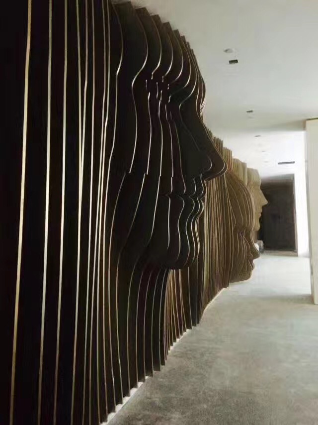 Dark electroplated metal feature wall with curved architectural panels