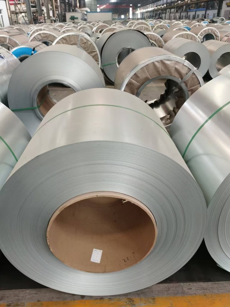 Large stainless steel coils with smooth metallic surfaces, available in different thicknesses and widths for industrial processing and fabrication.