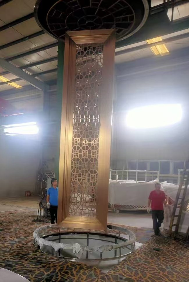 Custom fabricated stainless steel decorative door with an intricate patterned metal frame, manufactured for architectural entrance and interior applications.