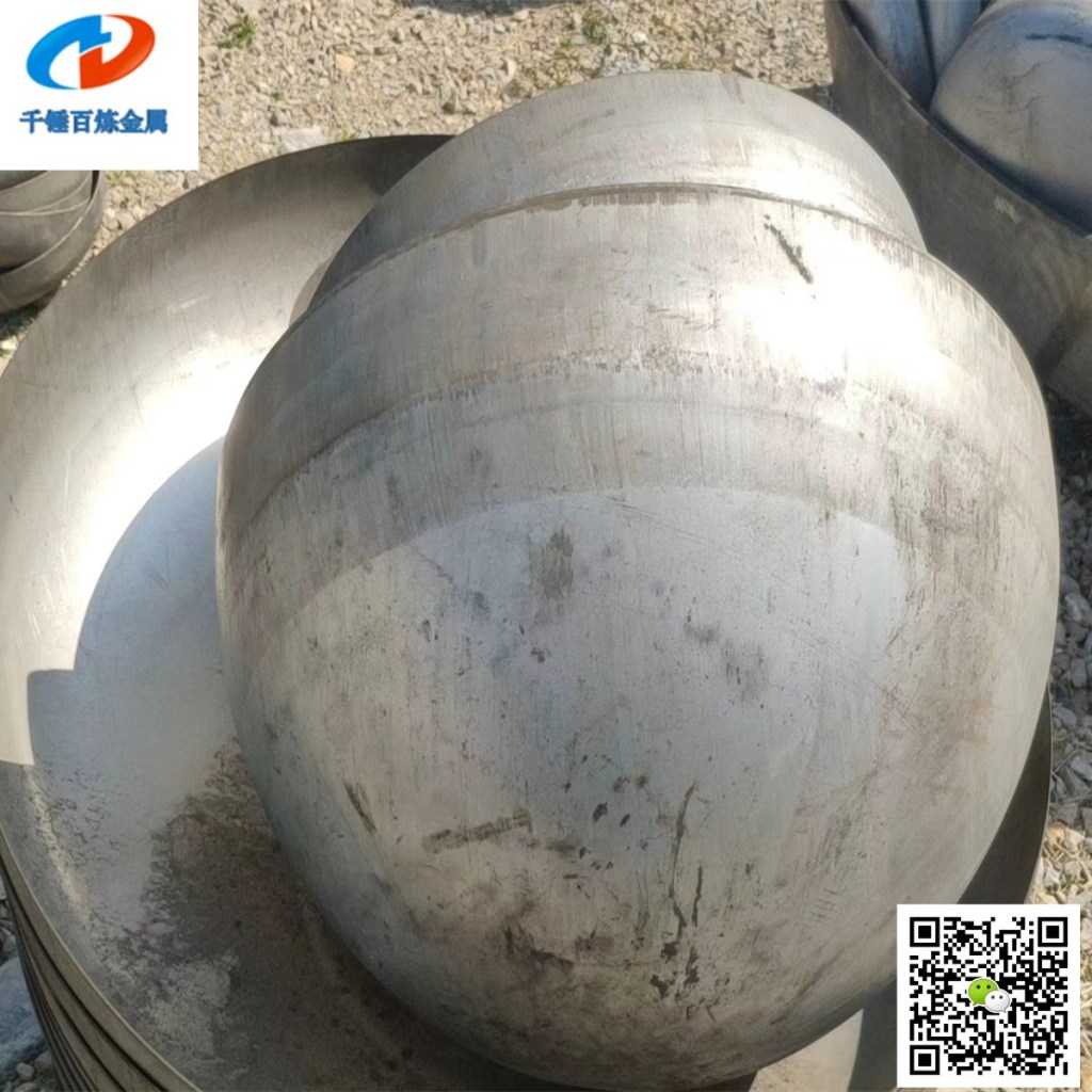 Large stainless steel hemispherical head showing a deep rounded shell and formed circular edge for pressure vessel and industrial tank fabrication.