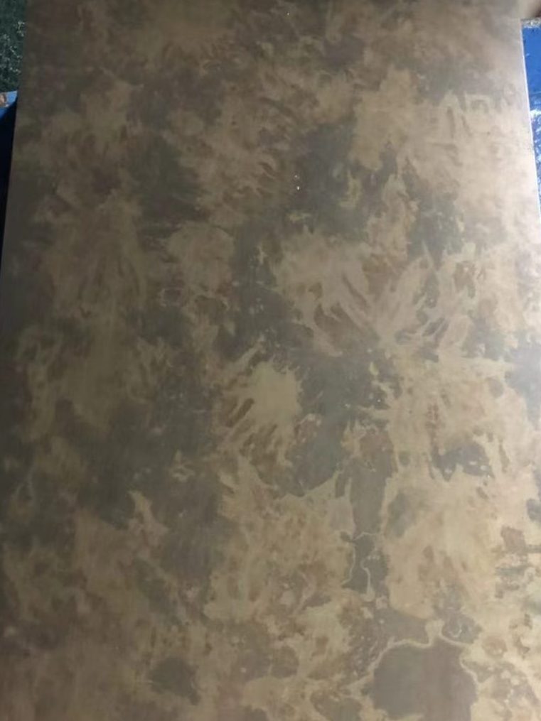 Antique copper stainless steel sheet with soft irregular cloud-like mottling in brown, bronze and muted gold tones, creating a distressed decorative metal surface.