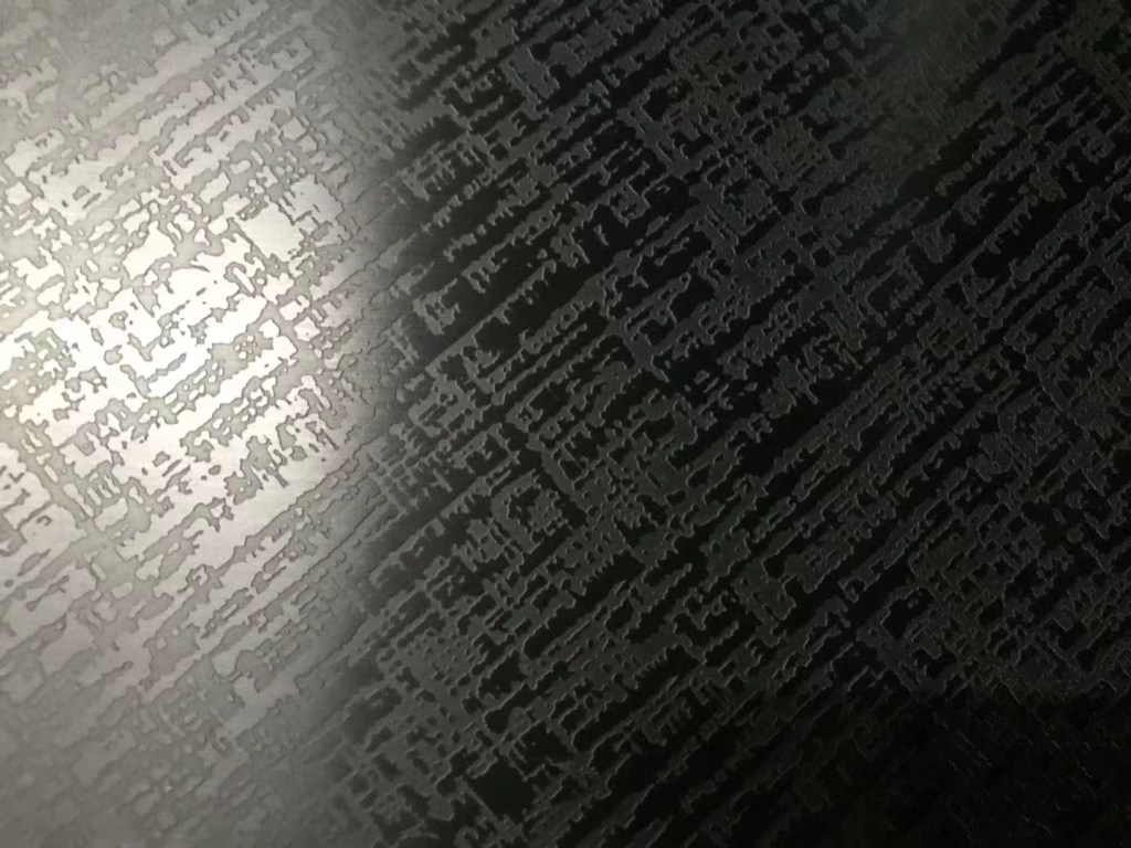 Black and charcoal stainless steel sheet with irregular intersecting lines, broken linear marks and abstract distressed patterns, creating a dark textured decorative finish for project-specific stainless steel surface requirements.