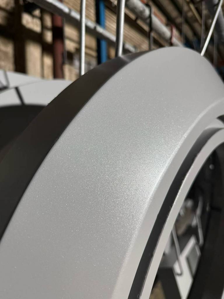 Grey powder-coated curved metal component with textured finish