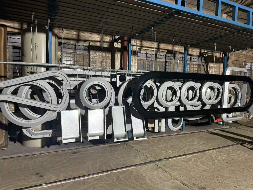 Grey powder-coated custom fabricated metal parts hanging in workshop