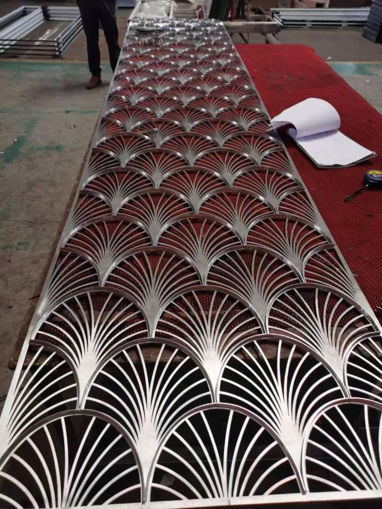 Custom stainless steel partition panel with repeating fan-shaped geometric patterns, fabricated for decorative walls, screens and architectural interior applications.