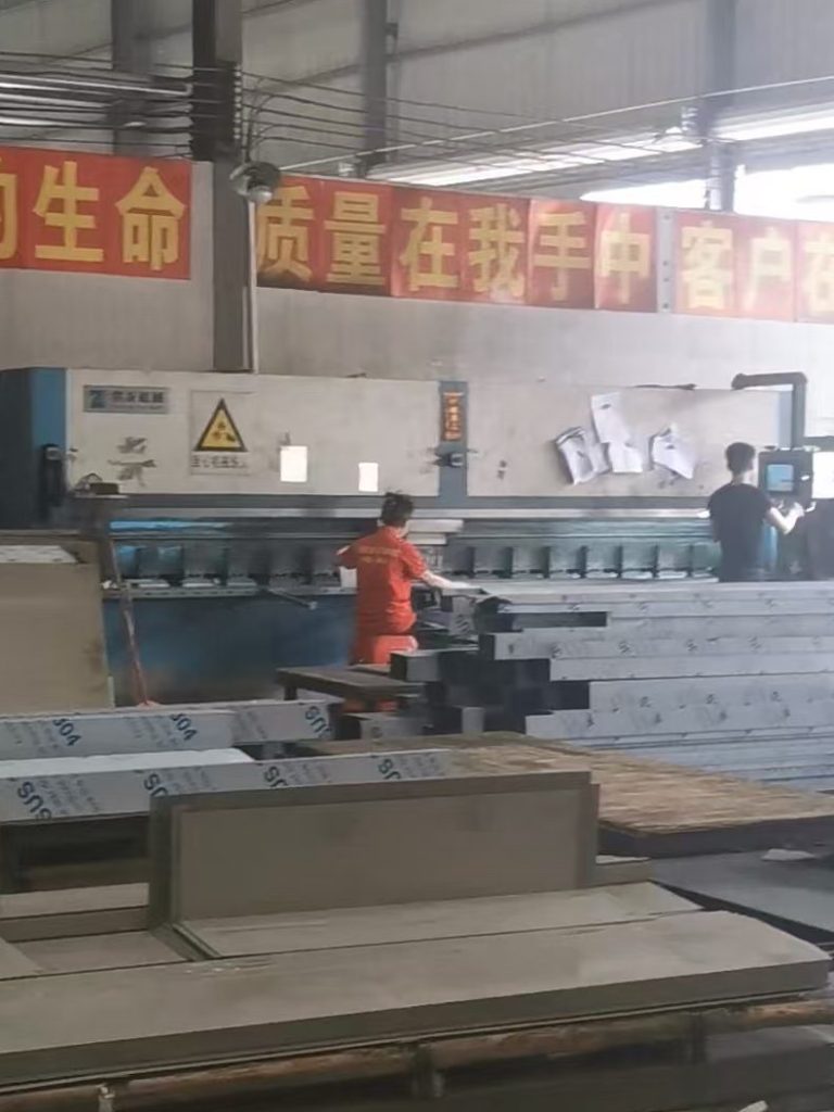 V-grooving machine processing stainless steel sheets for precision bending and custom architectural metal fabrication.